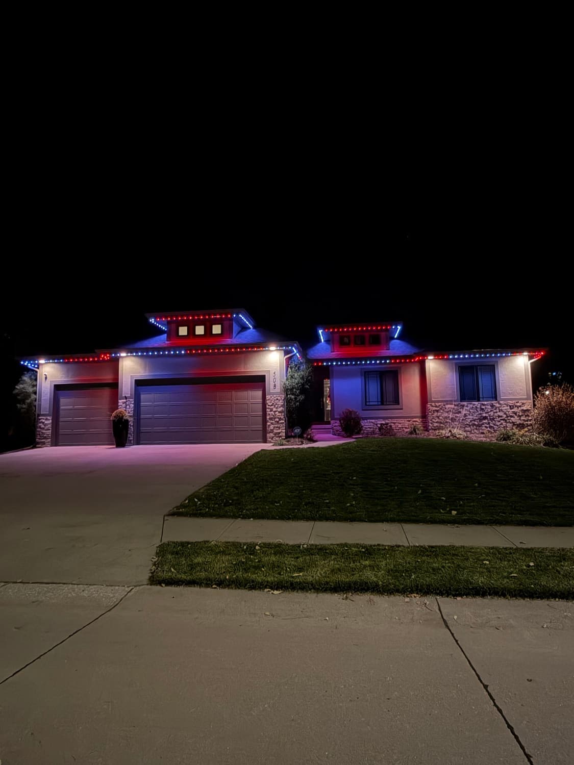 Home lit in red, white, and blue permanent lighting for a patriotic display.
